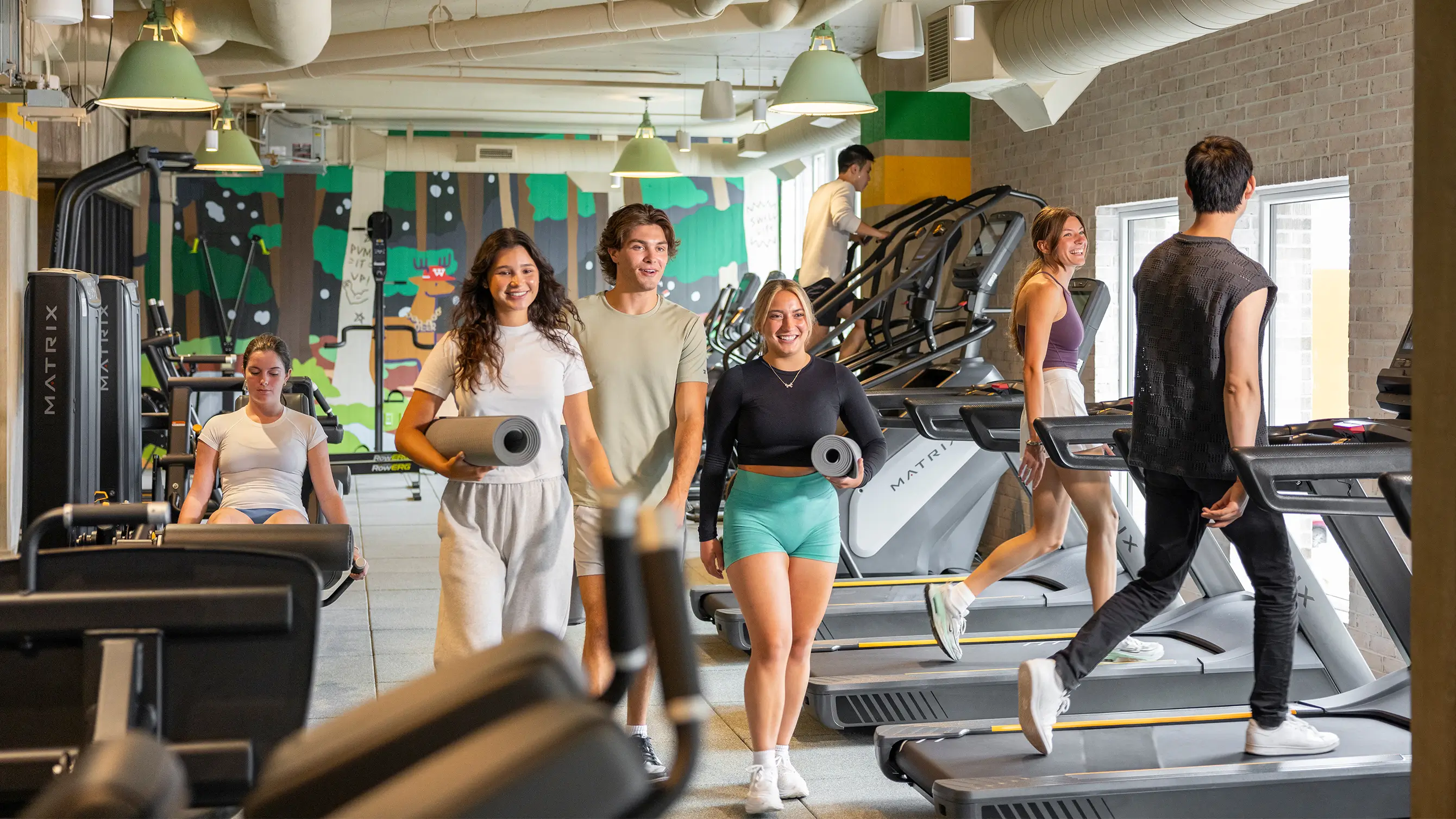 a group of people walking in a fitness center